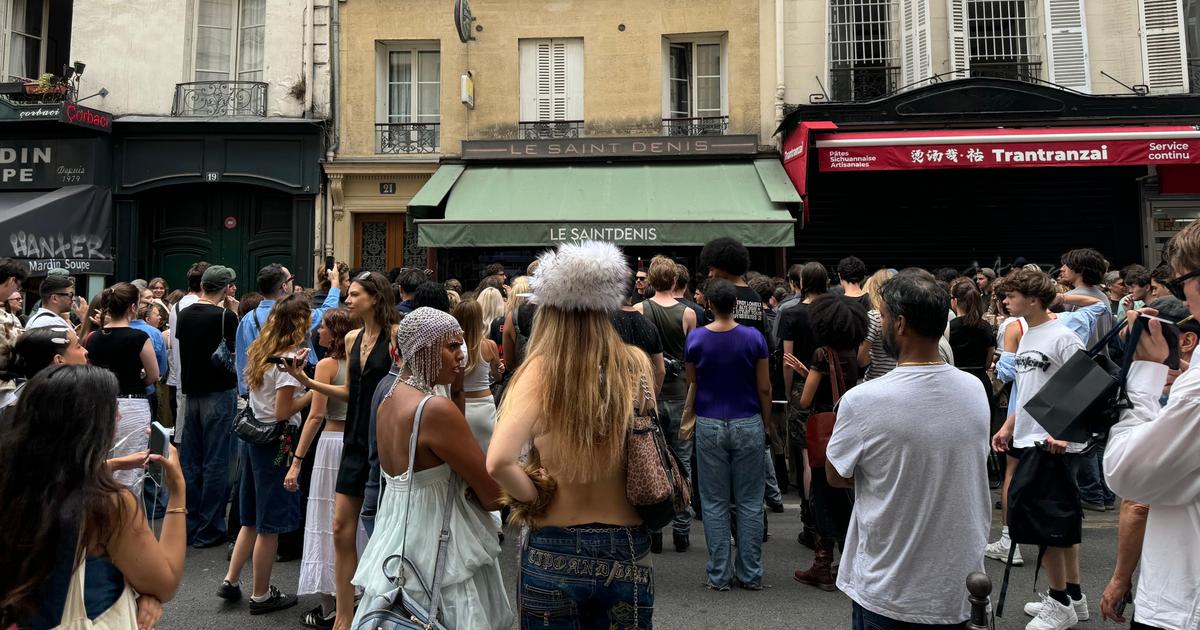 un influenceur réunit ses abonnés dans une rue de Paris pour regarder le premier défilé Dior de Jonathan Anderson sur écran géant