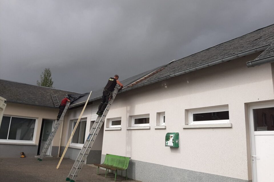 La toiture de l'école en train d'être protégée jeudi 26 juin.
