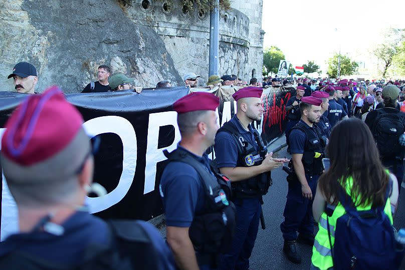 La police forme une ligne séparant les manifestants d'extrême droite des participants à la marche des fiertés à Budapest, en Hongrie, le samedi 28 juin 2025.