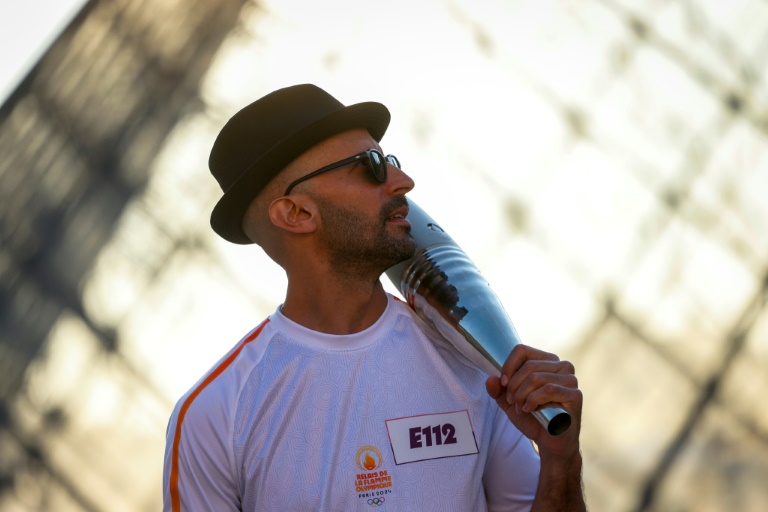 JR devant la Pyramide du Louvre à Paris le 14 juillet 2024 (GEOFFROY VAN DER HASSELT)