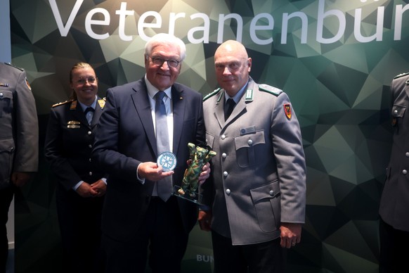 epa12152290 Lieutenant Colonel Michael Krause (R), chief of the Veterans' Office, poses for a photograph with German President Frank-Walter Steinmeier (C) during the latter's visit to the Bu ...