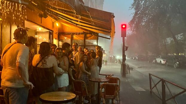 Paris (XVe), ce mercredi soir. A quelques centaines de mètres de la tour Eiffel, plusieurs touristes se sont réfugiés sous la terrasse d'un bar. LP/CB
