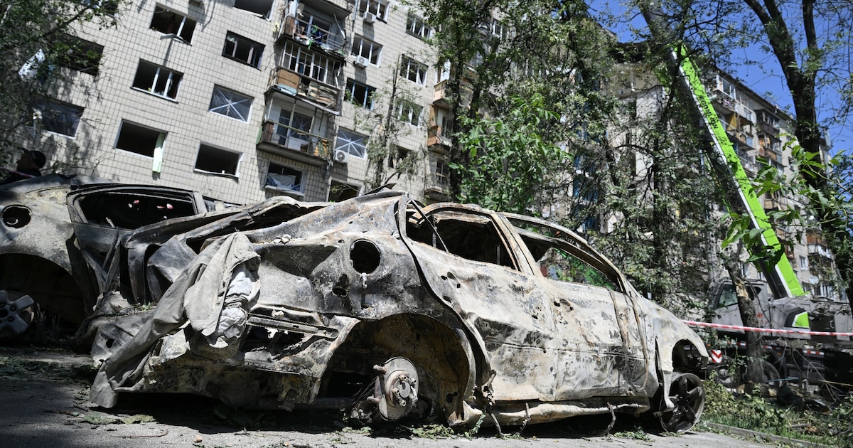 Des épaves de voitures devant un immeuble résidentiel endommagé par une frappe de missile russe la veille, le 18 juin 2025 à Kiev, en Ukraine