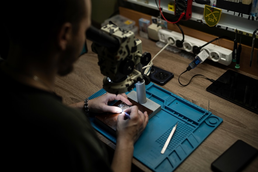 Un soldat ukrainien du bataillon de drones du 225e régiment d'assaut séparé soude un microprocesseur dans un atelier tenu secret, le 12 juin 2025 