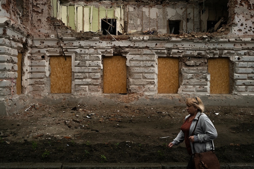Une femme passe à proximité d'un bâtiment détruit par un bombardement russe, le 12 juin 2025 à Soumy, dans le nord-est de l'Ukraine 