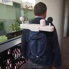 Basile Chaix, directeur de recherche à l'Inserm, portant une station météo sur son dos.