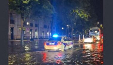une voiture de police diffuse la musique de "Titanic" dans une rue inondée