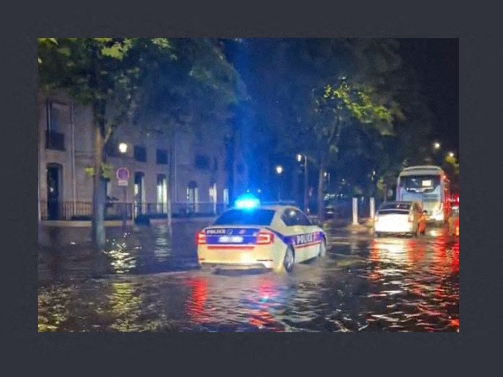 une voiture de police diffuse la musique de "Titanic" dans une rue inondée