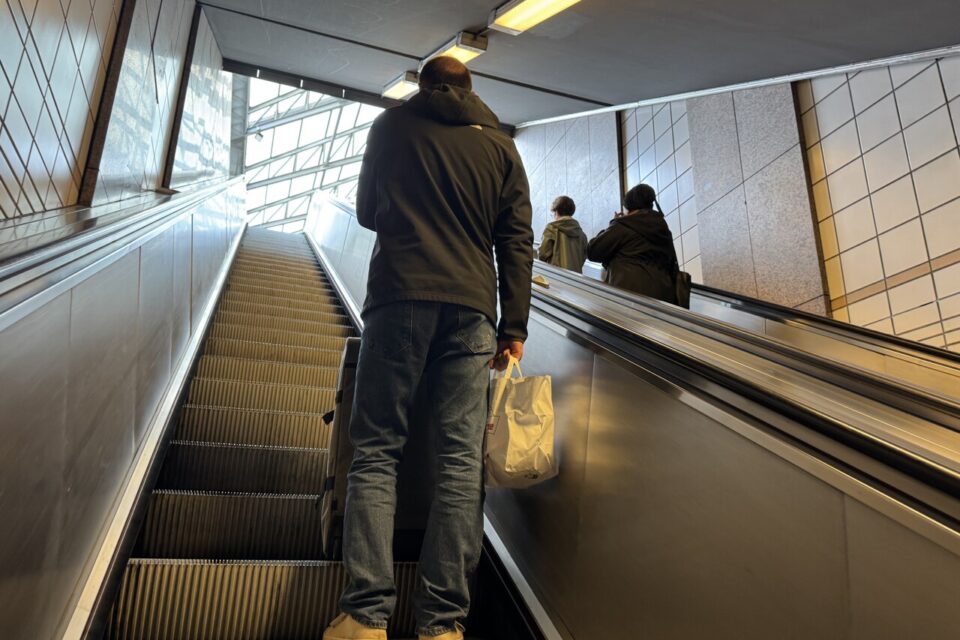 Mathieu et sa grosse valise dans l'escalator, en direction de la sortie du métro 