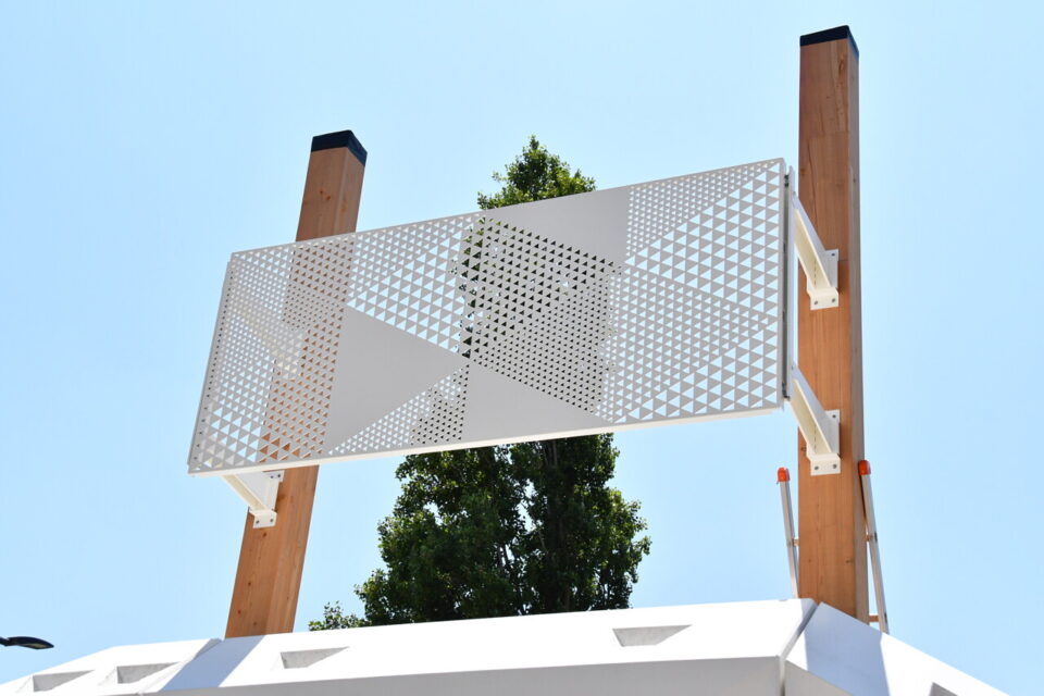 La peau métallique perforée adopte le même motif que le socle : des triangles.