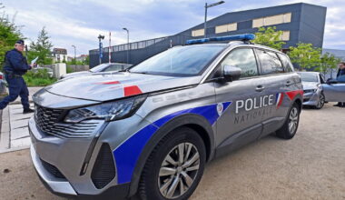 Nancy. Il pose un pistolet en plastique sur le capot d’une voiture de police