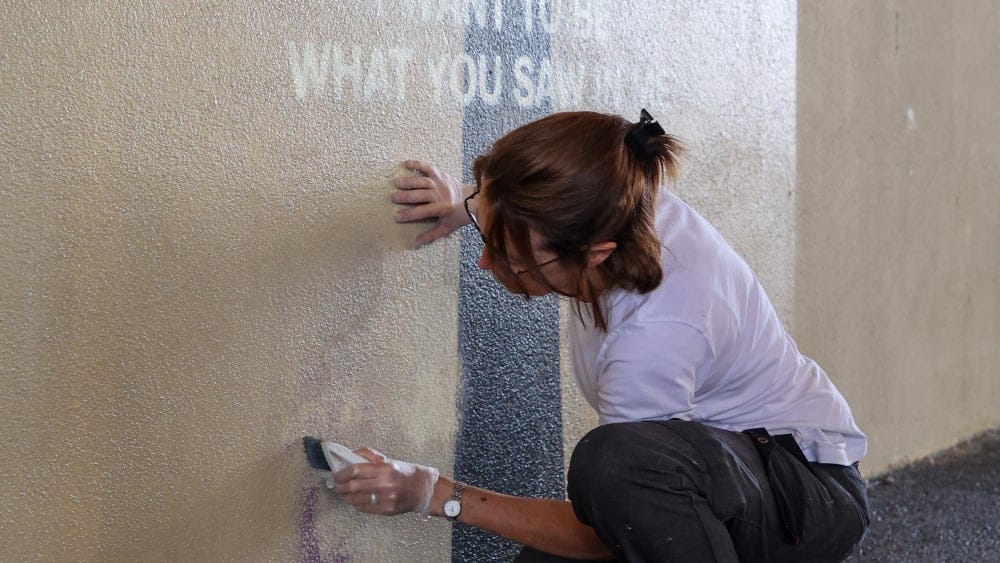 Une personne nettoie l’oeuvre de Banksy qui a été dégradée.
