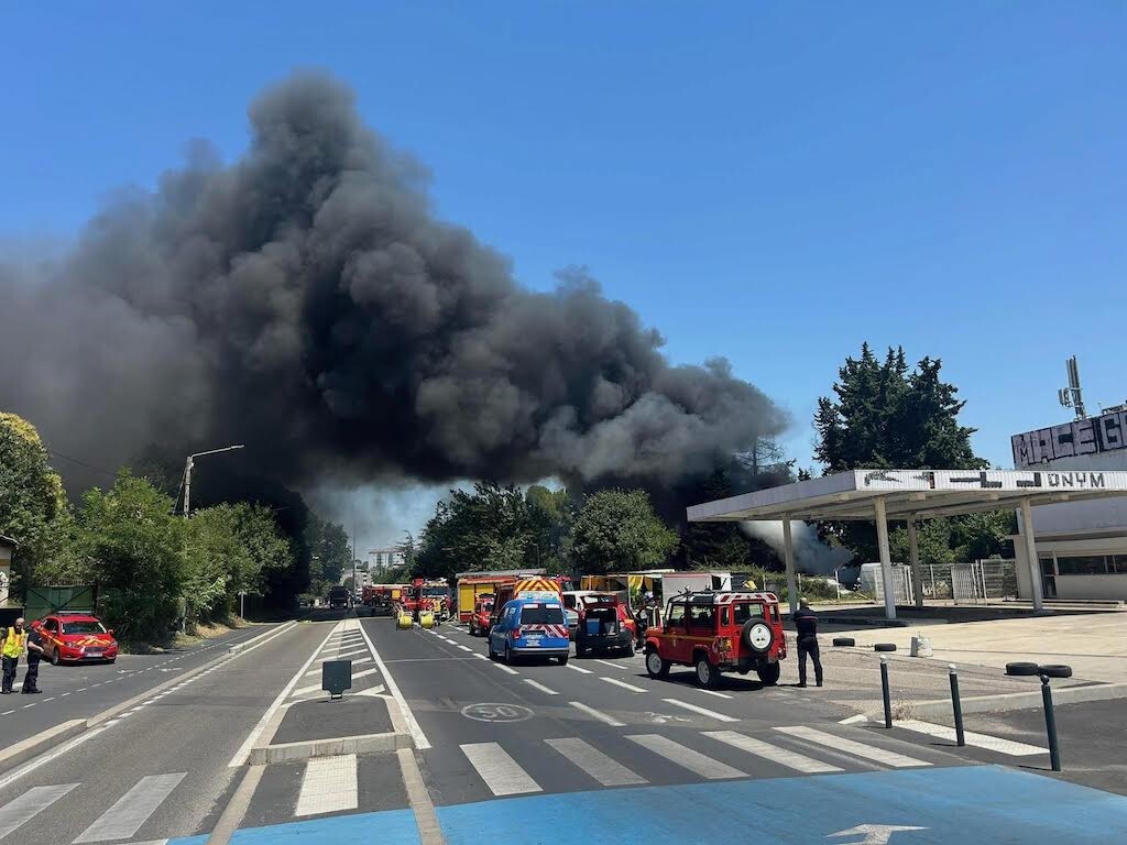 de nombreuses voitures sont en feu sur le parking d'une concession automobile