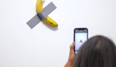 Une visiteuse photographiant l’œuvre « Comedian » de Maurizio Cattelan lors de l’inauguration de l’exposition « Dimanche sans fin » au Centre Pompidou Metz