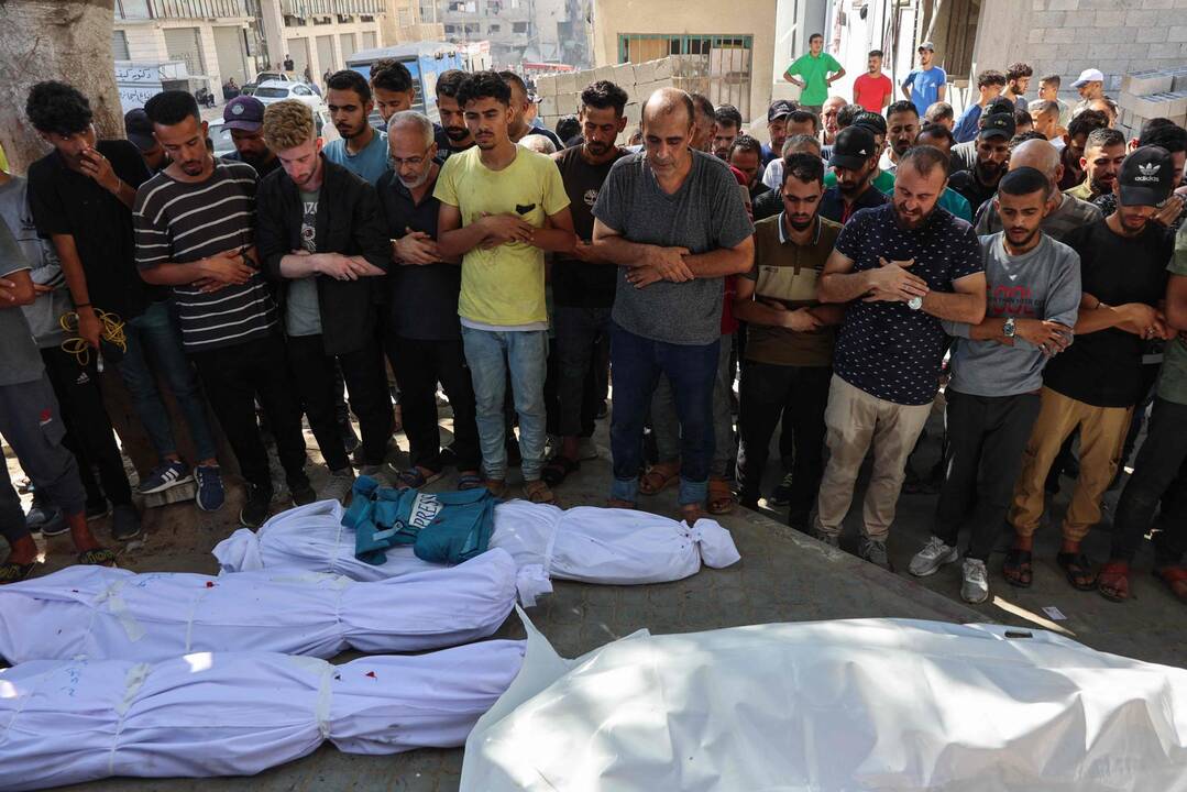 Des Palestiniens prient près des corps de leurs proches tués lors d'une frappe israélienne contre la cafétéria Al-Baqa, sur le front de mer de Gaza, dont le journaliste Ismail Abu Hatab, à l'hôpital Al-Shifa de la ville, le 30 juin 2025. — © OMAR AL-QATTAA / AFP