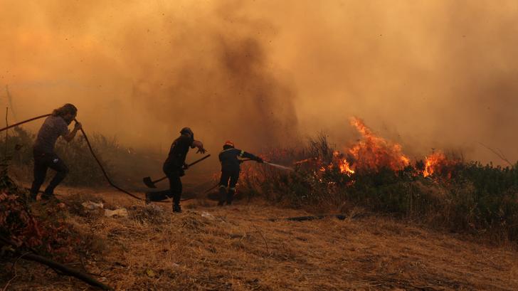 Des pompiers grecs luttant contre les flammes près d’Athènes, le 26 juillet 2025.