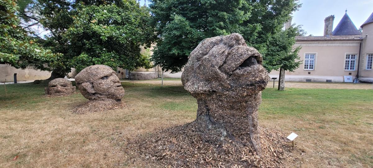 Des têtes de géant émergent du sol au parc du château Lescombes.