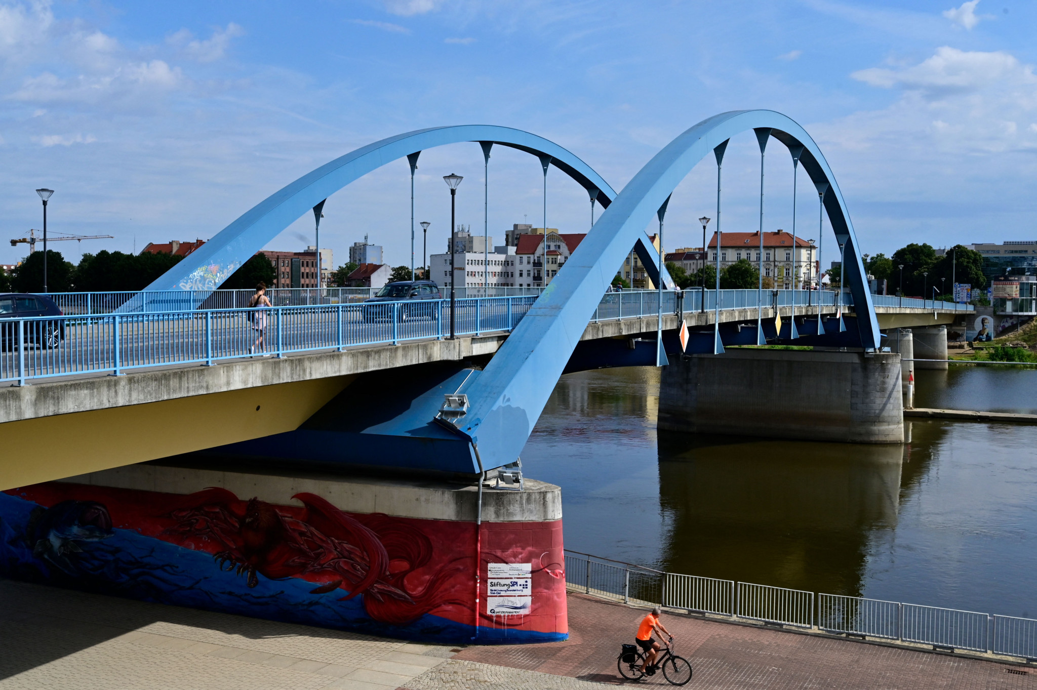 Vue du pont Stadtbruecke traversant l’Oder entre Frankfurt an der Oder en Allemagne et Slubice en Pologne, avec un cycliste au premier plan et Slubice en arrière-plan, le 16 août 2021.