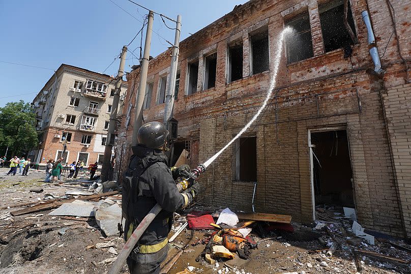 Des secouristes éteignent l'incendie d'un bâtiment détruit par une attaque de drone russe à Kharkiv, le 7 juillet 2025