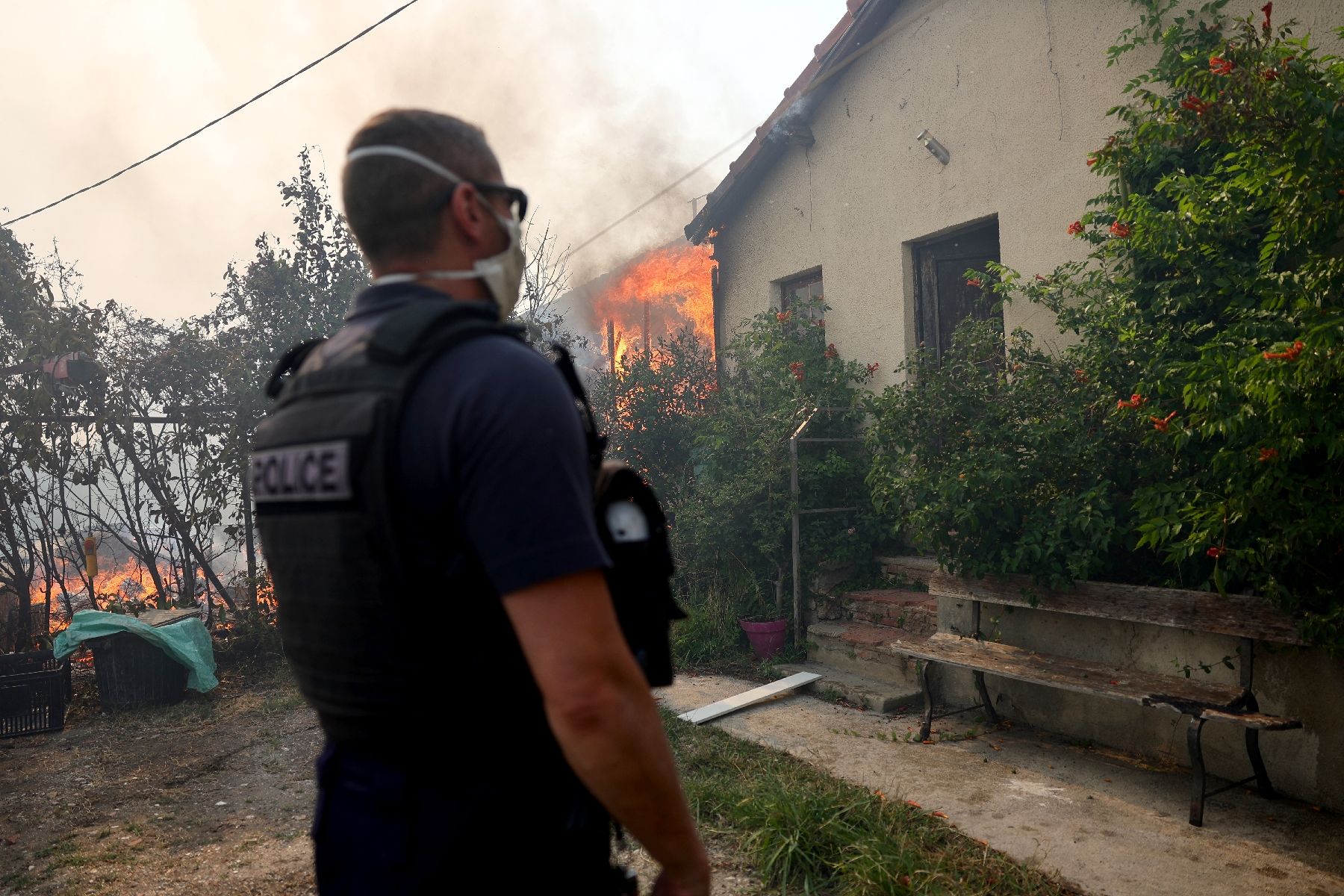 Un policier près d'un incendie de forêt se propageant dans le quartier de l'Estaque à Marseille, le 8 juillet 2025 dans les Bouches-du-Rhône