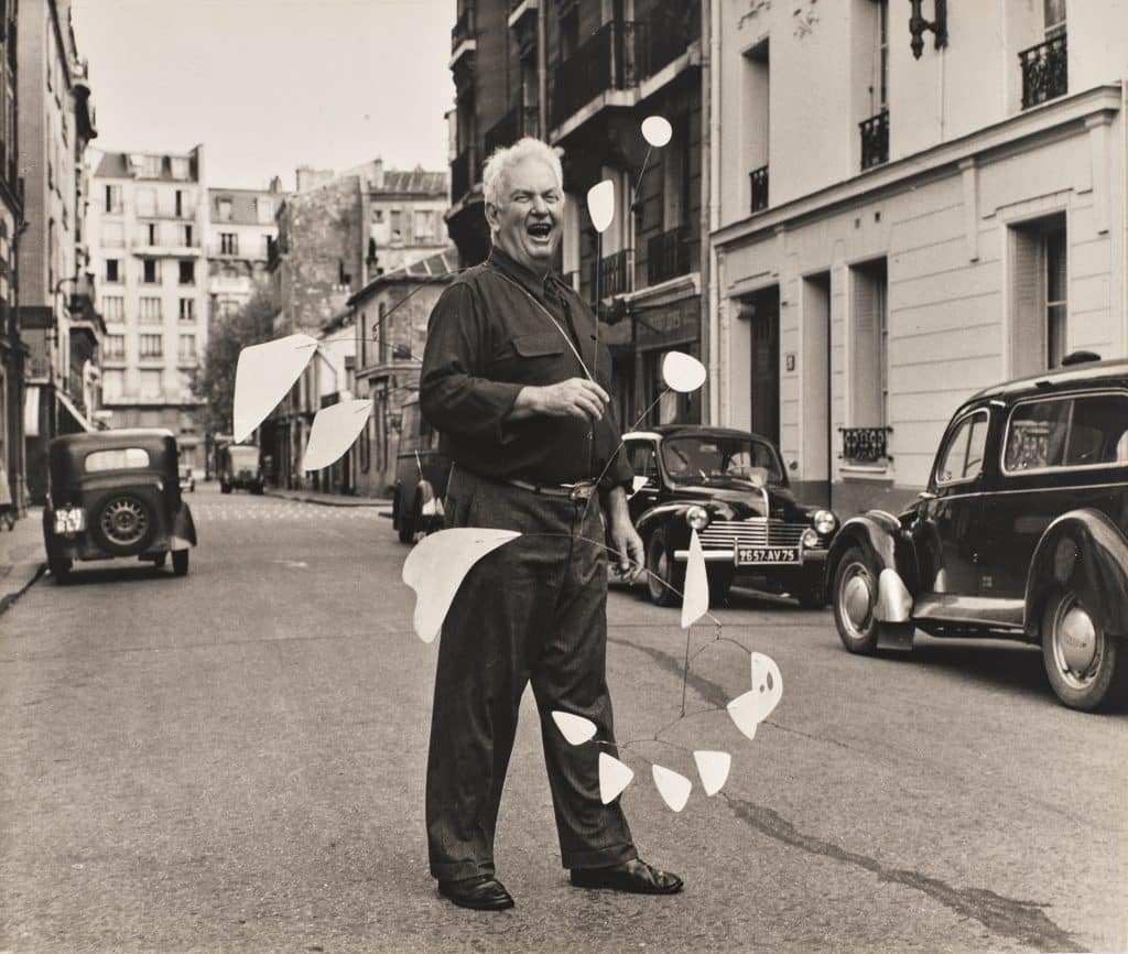 Agnès Varda, Alexander Calder devant son atelier, Paris 14e, octobre 1954 © Succession Agnès Varda / 2025 Calder Foundation, New York / ADAGP, Paris