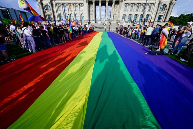 Un drapeau arc-en-ciel géant déployé devant le Bundestag, la veille du défilé du Christopher Street Day pour les droits des minorités sexuelles et de genre, à Berlin, le 25 juillet 2025.