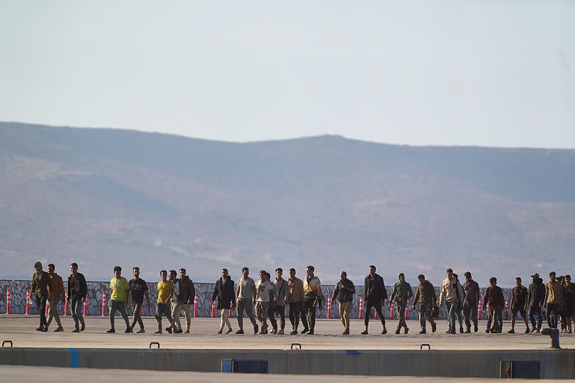 Des migrants secourus au sud de la Crète marchent après leur arrivée au port de Lavrio, 10 juillet, 2025
