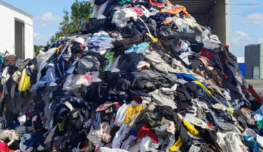 Le Relais déverse plus d’une tonne de vêtements dans une zone commerciale pour protester contre le traitement des habits en fin de vie
