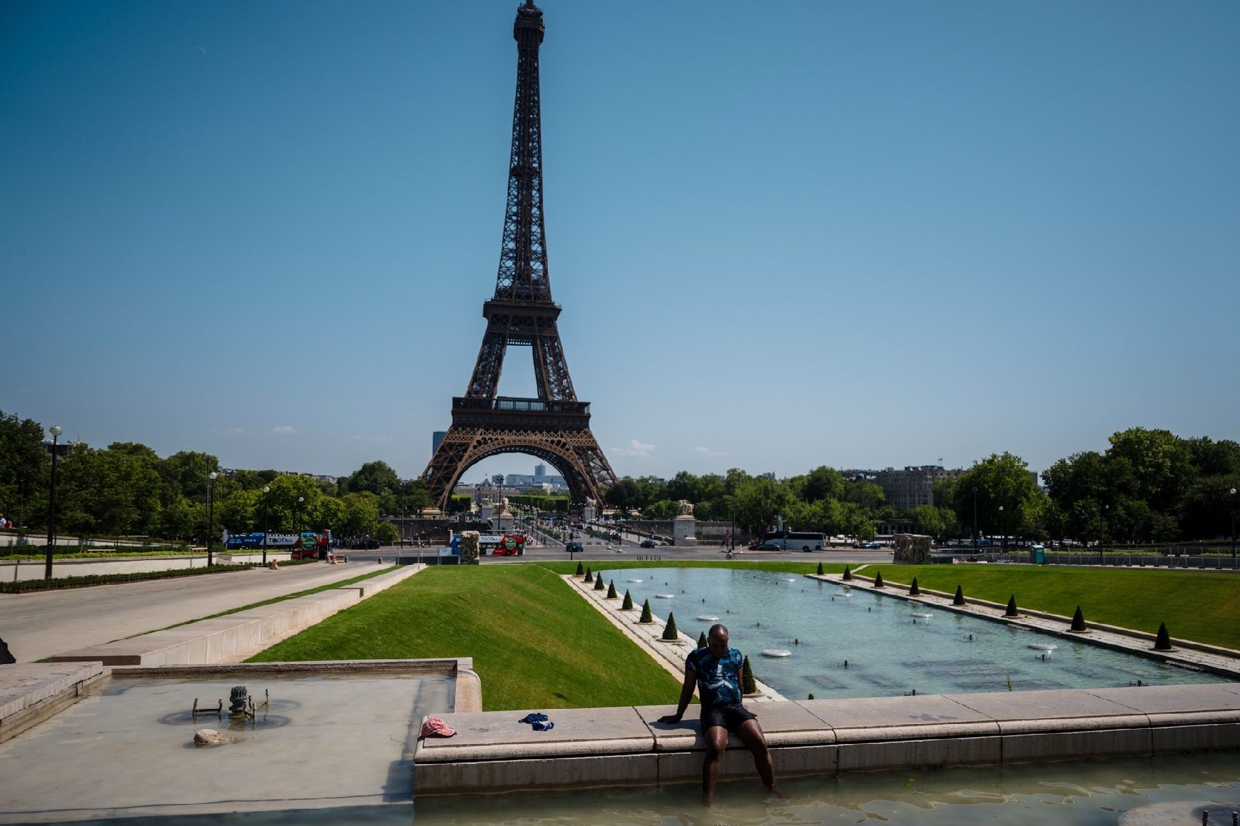 Un homme se rafraichit pendant une vague de chaleur à Paris, au Trocadéro, face à la tour Eiffel, le 1er juillet 2025