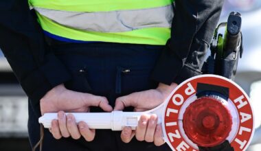 Un policier allemand tient un panneau "Stop police", à la frontière polonaise, à Guben (est de l'Allemagne), le 9 mai 2025