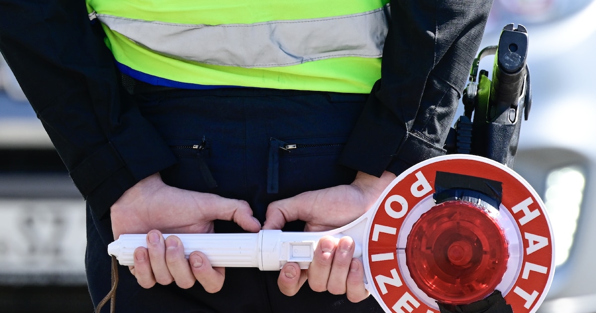Un policier allemand tient un panneau "Stop police", à la frontière polonaise, à Guben (est de l'Allemagne), le 9 mai 2025
