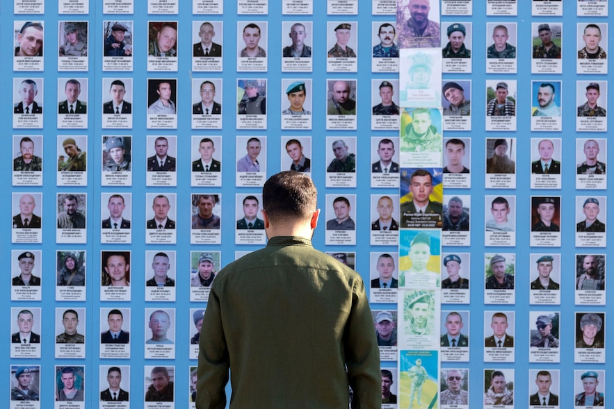 Dans cette photo distribuée par le service de presse de la présidence ukrainienne le 15 juillet 2025, le président Volodymyr Zelensky honore des soldats ukrainiens morts pour défendre leur pays.