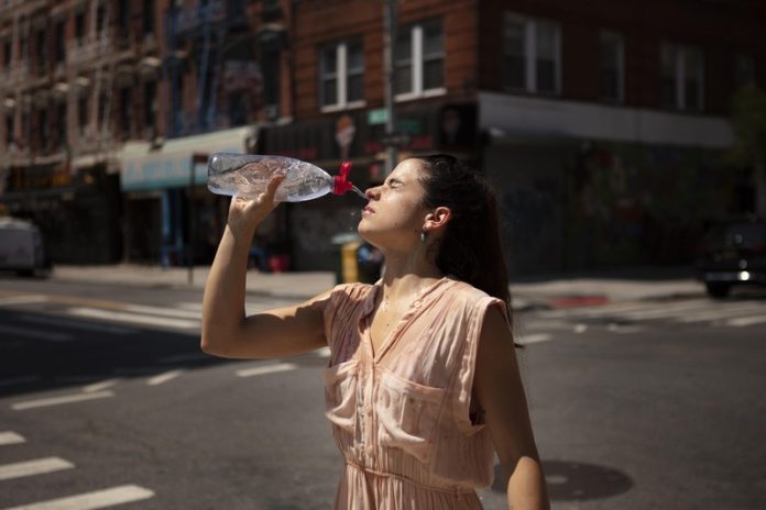 alerte canicule France chaleur extreme vigilance orange rouge Ma Santé Une femme qui subit la canicule en ville en France en vigilance rouge.