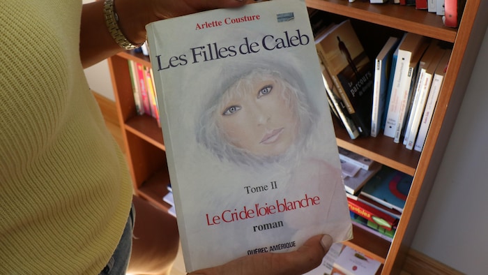 Un exemplaire des Filles de Caleb entre les mains de Naomi Fontaine.