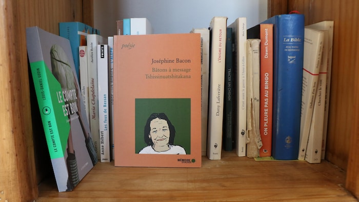 Le recueil Bâtons à message / Tshissinuatshitakana au milieu d'autres livres.