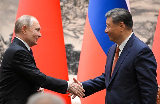 Le président russe, Vladimir Poutine, et le président chinois, Xi Jinping, échangent une poignée de main pendant une réunion, à Pékin, le 16 mai 2024.