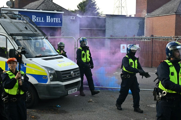 

Des fusées éclairantes lancées sur des policiers lors d'une manifestation devant l'hôtel Bell, censé héberger des demandeurs d'asile, à Epping, au nord-est de Londres, le 20 juillet 2025, après que la police a inculpé un demandeur d'asile pour infractions sexuelles