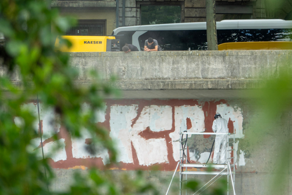 Des tags en cours d'effaçage sur les façades des quais du Rhône ce mardi 22 juillet 2025.
