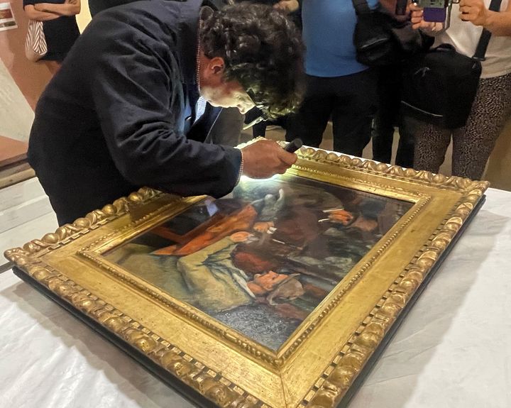 Matthieu Leverrier, régisseur des collections au musée d'Orsay, procède au constat d'état du tableau de Paul Cezanne, "Les joueurs de cartes", le 11 juin 2025, au musée Granet d'Aix-en-Provence. (VALERIE GAGET  / FRANCEINFO CULTURE)