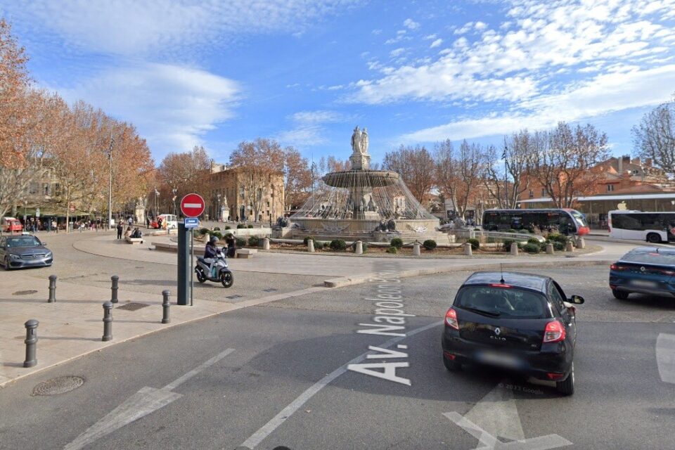 Vue de la Rotonde à Aix où les véhicules motorisés partant sur la droite tandis que les taxis stationnent et chargent leurs clients sur la gauche.