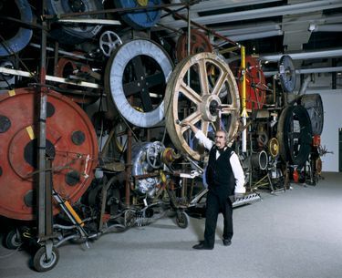 Jean Tinguely pose, en 1988, devant sa sculpture « Fata Morgana », qui mesure 13 mètres de long.