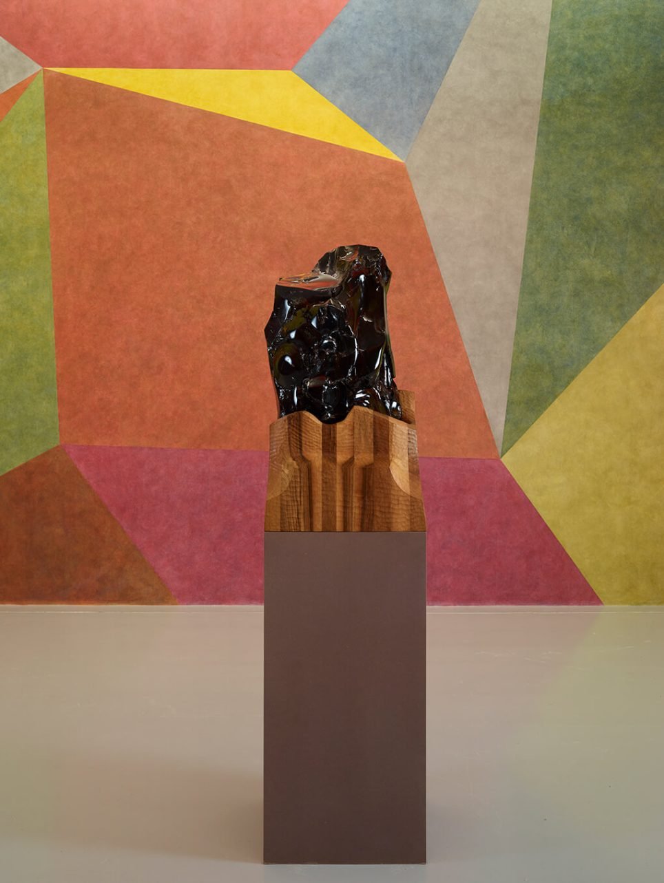 Organiques, brillantes et énigmatiques, les sculptures en obsidienne d’Othoniel, inspirées des roches volcaniques des îles Éoliennes, contrastent avec les œuvres minimalistes de la Collection Lambert – ici <em>Invisibility Face #1</em> (2015) devant <em>Wall Drawing #538</em> (1987) de Sol Lewitt. Pourtant, une même épure s’en dégage.