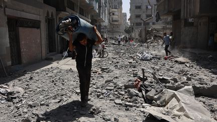 Des Palestiniens dans les décombres d'habitations touchées par des bombardements israéliens dans la ville de Gaza, le 19 août 2025. (OMAR AL-QATTAA / AFP)