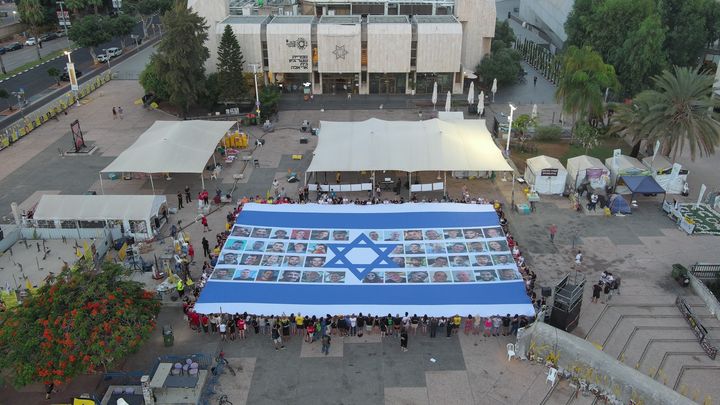 Un immense drapeau israélien avec le visage des otages a été déployé à Tel Aviv, le 17 août 2025, dans le cadre d'une mobilisation nationale. (YAIR PALTI / ANADOLU)