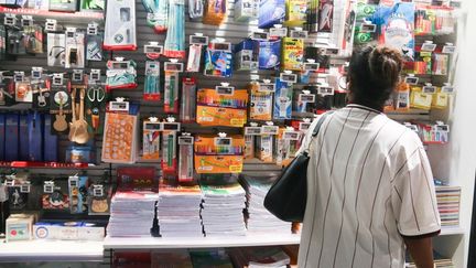 Une femme devant un rayon de fournitures scolaires, le 29 juillet 2025 à Paris. (QUENTIN DE GROEVE / HANS LUCAS / AFP)