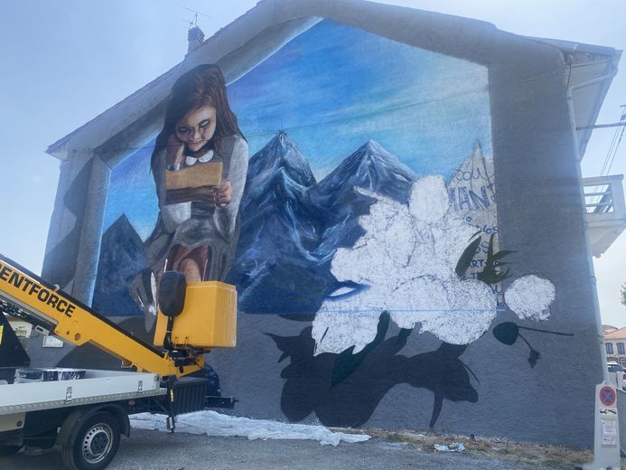 L’artiste tarbais Enzo est en train d’avancer sa fresque place du foirail.