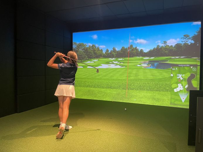 Joueuse expérimentée s’entraînant dans un box pour perfectionner son swing.