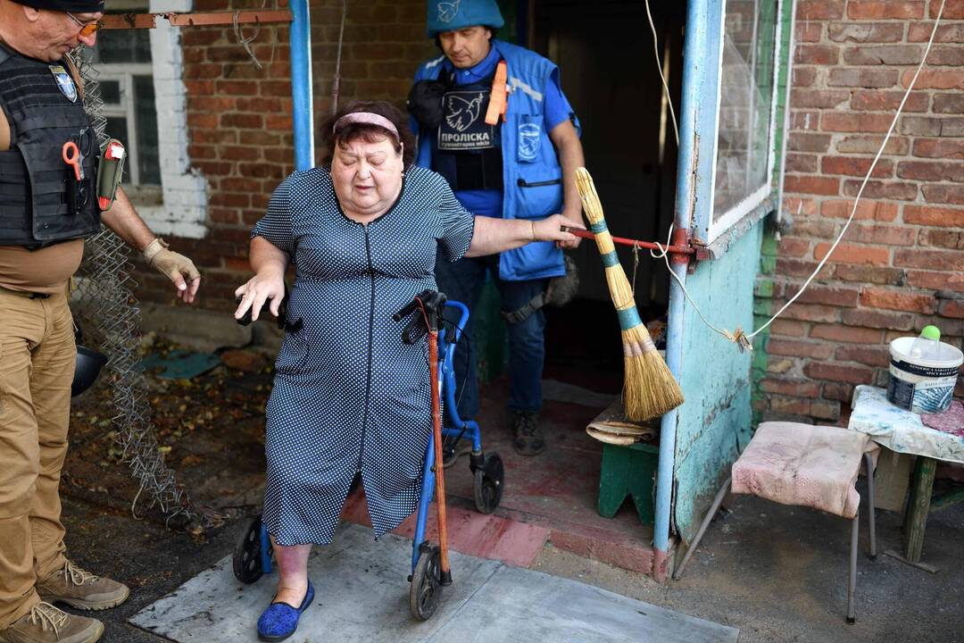 Une habitante de Kostiantynivka, diabétique et handicapée, est évacuée par Eugène à gauche et Oleg à droite. Kostiantynivka, 23 août 2025. — © Boris Mabillard pour Le Temps