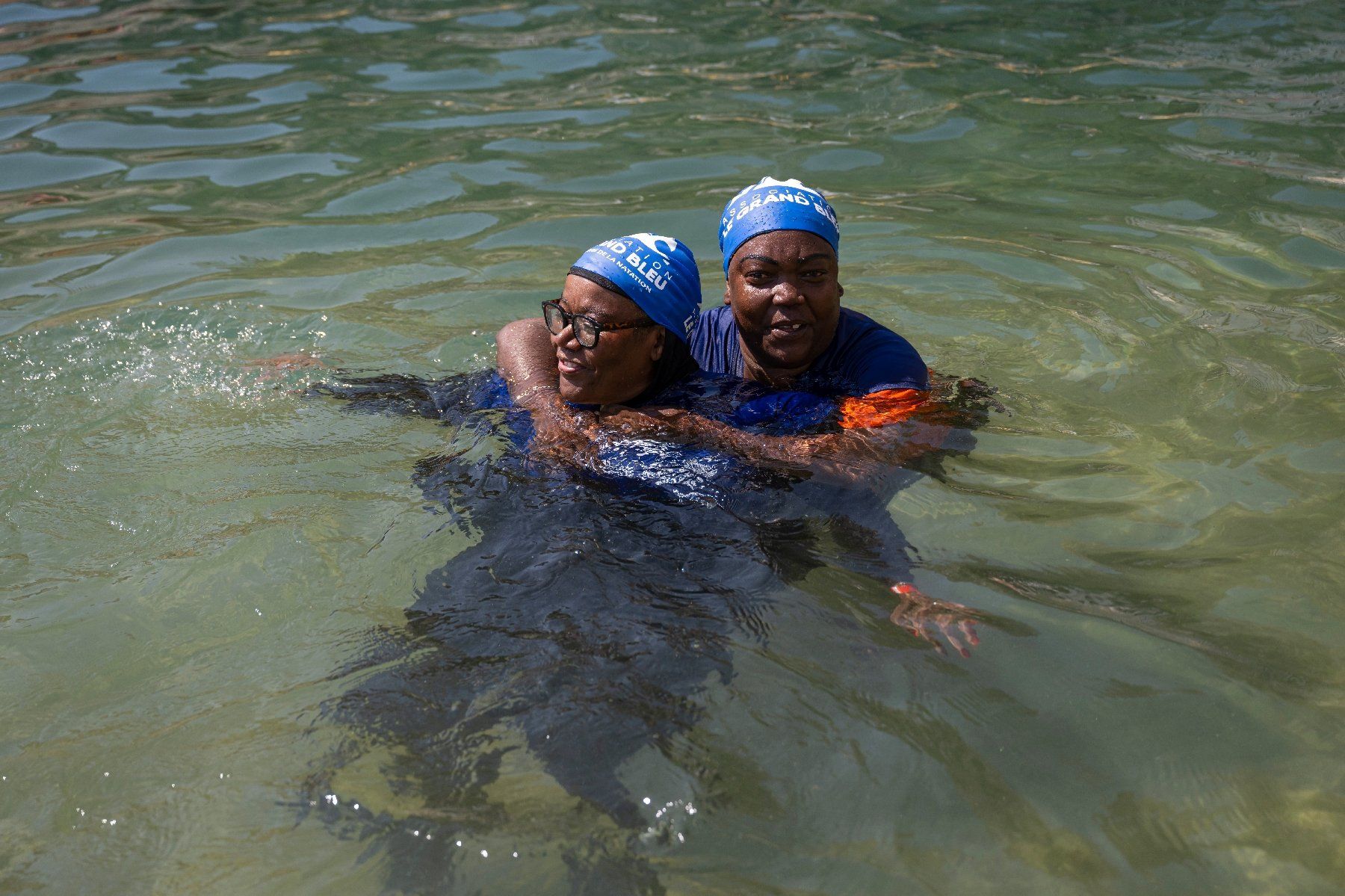 Nadia Hamada et son amie Zaina Moussahaziri participent à un cours de natation proposé aux mères des quartiers Nord de Marseille par l'association "Le Grand Bleu" dans une piscine d'eau de mer près du port de l'Estaque, le 11 août 2025