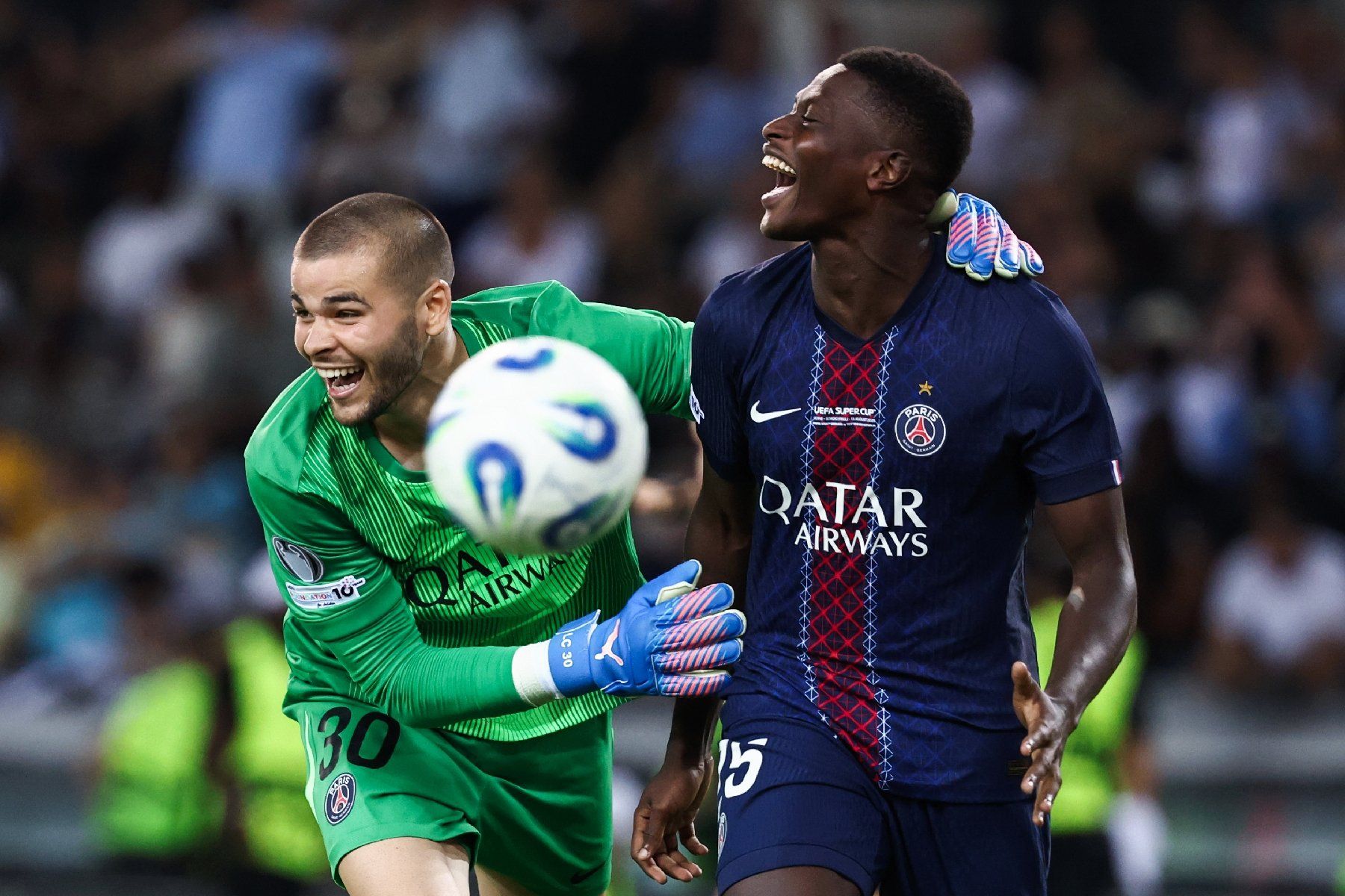 Le défenseur portugais du Paris SG Nuno Mendes (droite) est félicité par le gardien Lucas Chevalier après avoir inscrit le tir au but de la victoire en Supercoupe d'Europe contre Tottenham le 13 août 2025 à Udine (Italie)